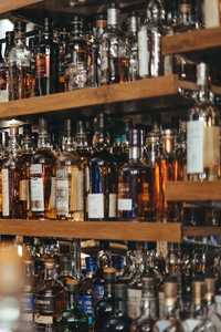 Photo of a bar with a selection drinks on multiple shelves.